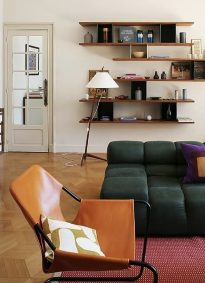 Un salon avec un canapé vert et du marron